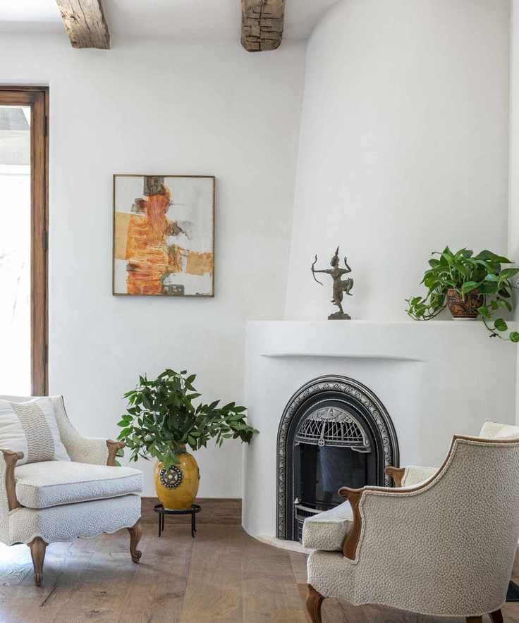 seating area with rounded chimney breast and two classic armchairs