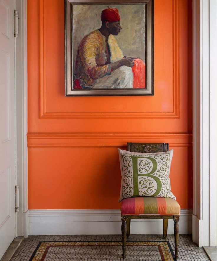 Entryway with orange painted wall and art