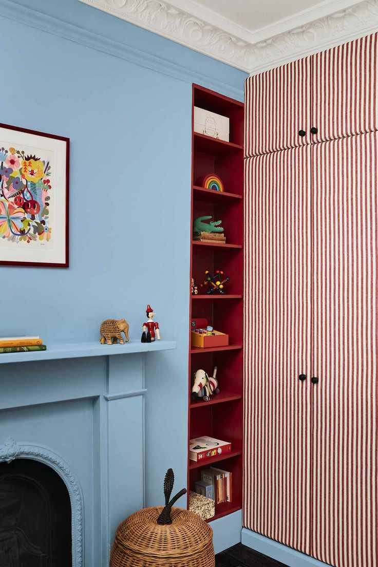 Playroom storage with blue walls and red storage alcove