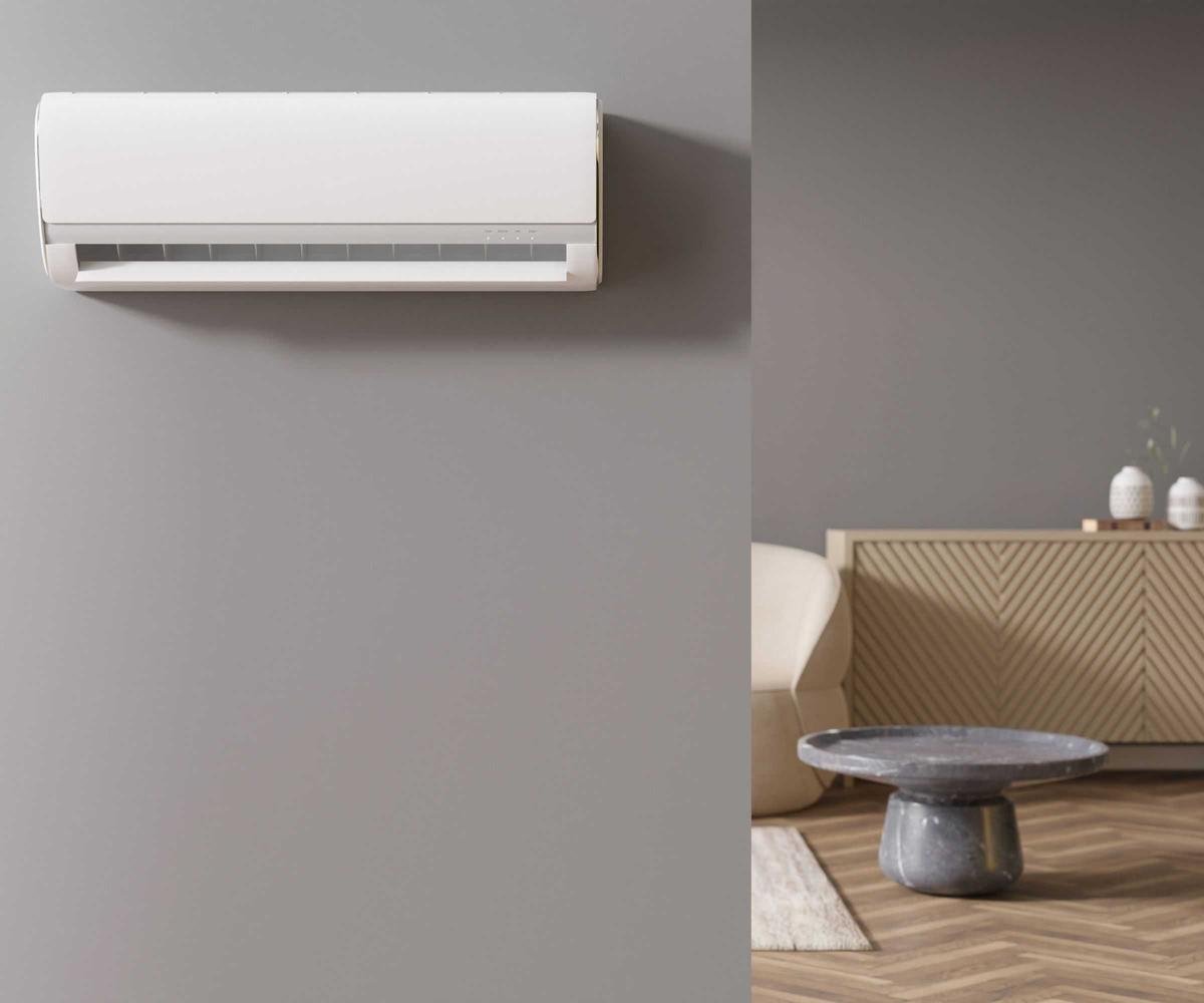 A white HVAC fen unit mounted to a grey painted wall. A living room visible through a doorway to the right hand side.
