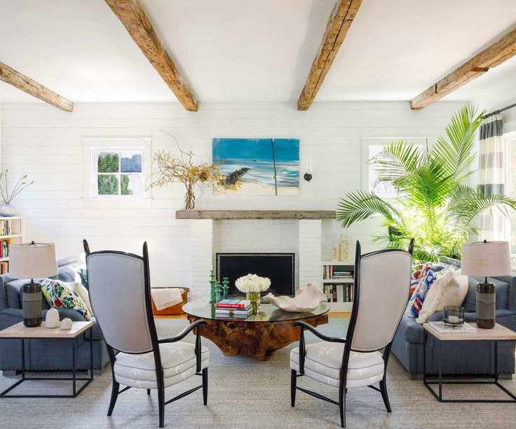 living room with white walls and ceilings with white armchairs and fireplace