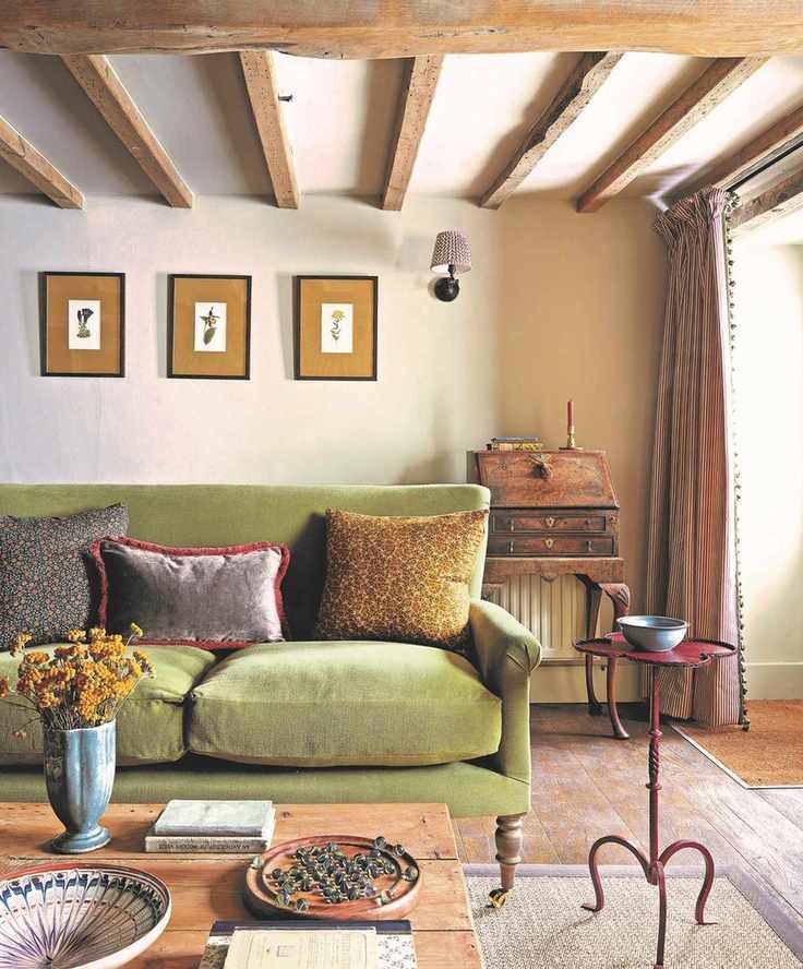 living room with green sofa, wooden beams and wooden bureau