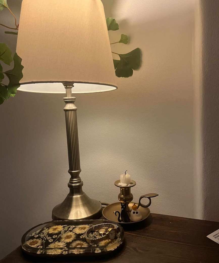 A bedside lamp featuring a Philips Hue bulb emitting warm light