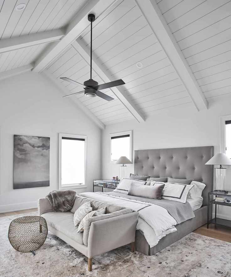 Bright bedroom with a white vaulted ceiling and plush furnishings