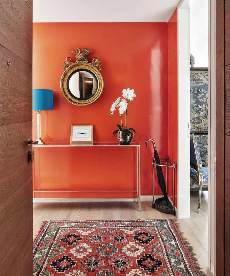 Hallway with striking orange-red feature wall and modern decor