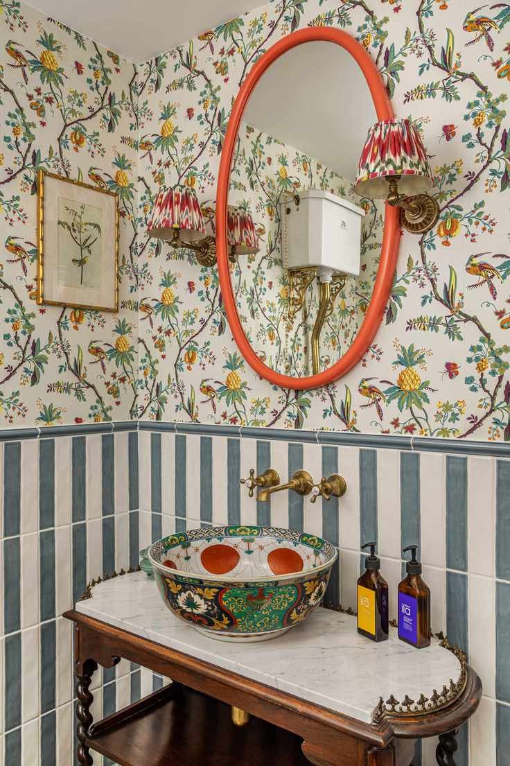 Half bathroom with striped and wallpapered wall and vanity