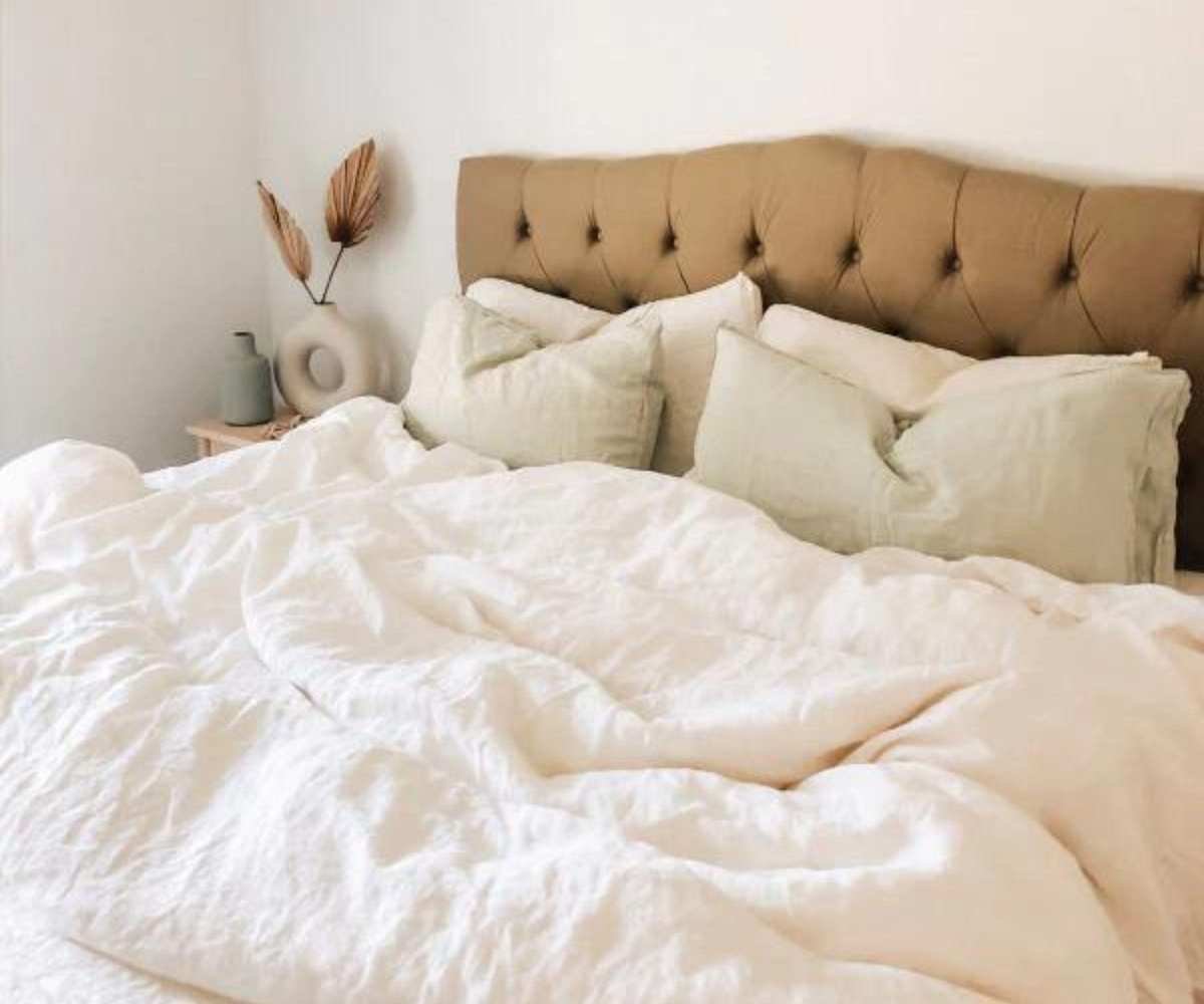 Brooklinen Down Comforter on a bed against a headboard.
