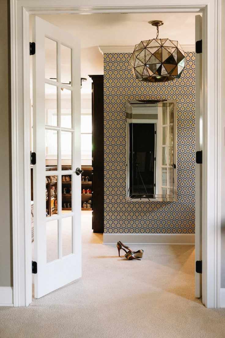walk in closet with French style doors, wallpaper, shoes to one side, vintage silver pendant light, carpet