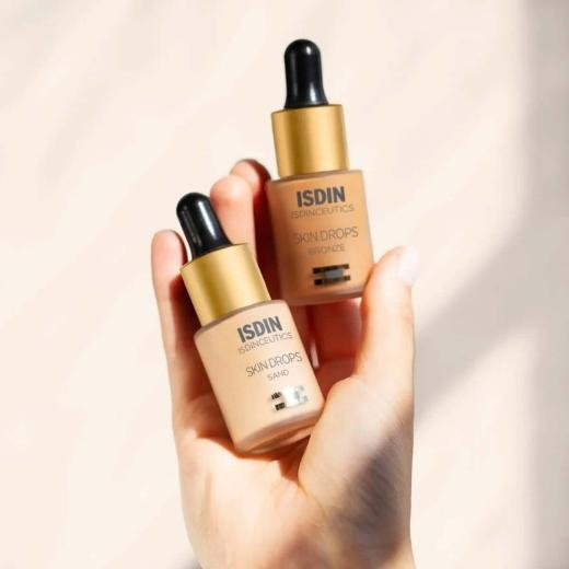 Bottles of ISDIN Skin Drops Make Up in sand and bronze