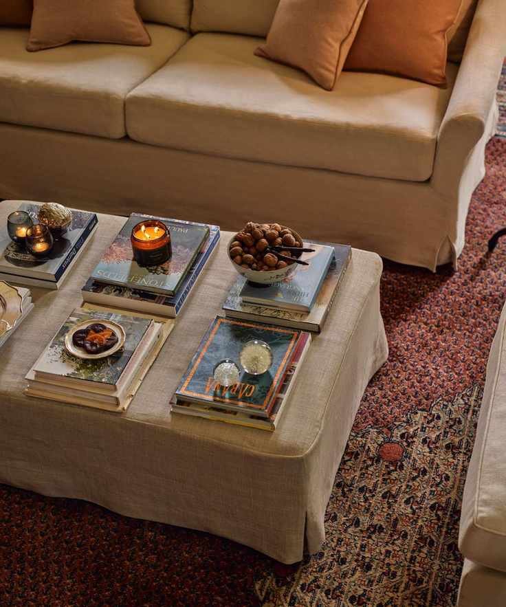 A coffee table with stacked books and candles
