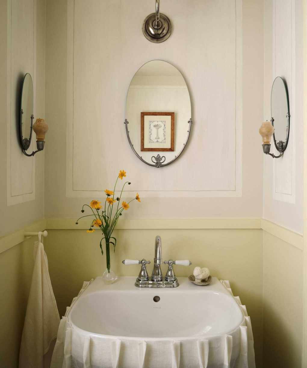 A powder room showcasing butter yellow lower walls and warm white panels.