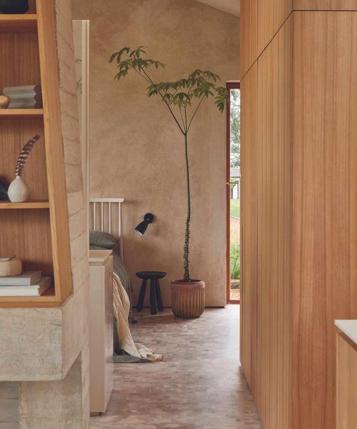 bedroom with pale earth colours and stone floor and wooden walls