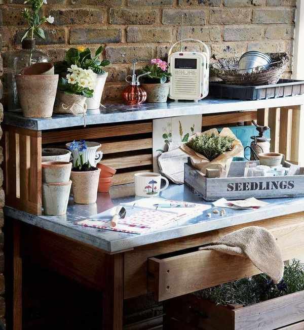 A wood work bench with metal countertop and shelf, used for planting seedlings in storage ideas for sheds.