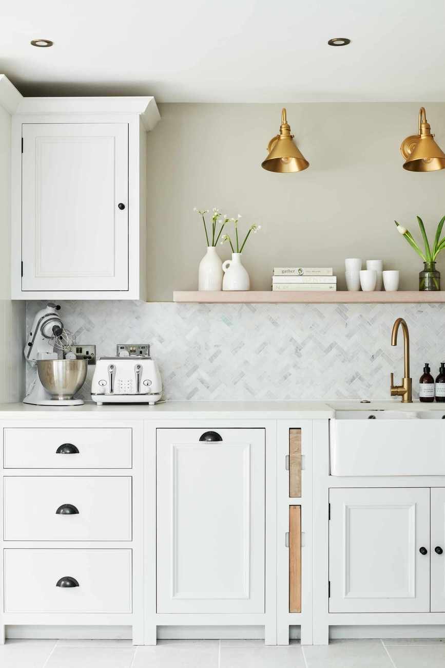 A white kitchen with a herringbone backsplash design
