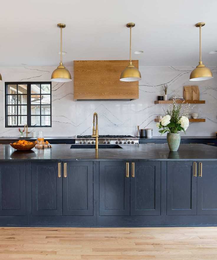 blue and marble kitchen with marble wall, blue cabinetry, hardwood floor, copper pendant lights, black countertop, open shelving, glazed wall units
