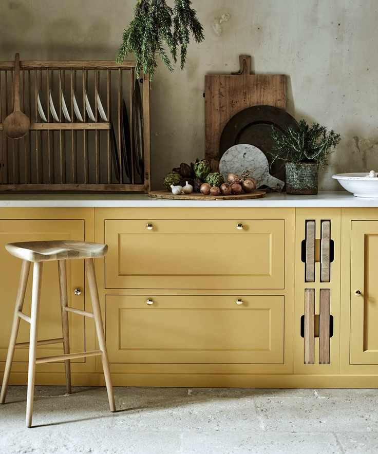 How to paint kitchen cabinets shown in buttermilk yellow with wooden kitchen accessories.