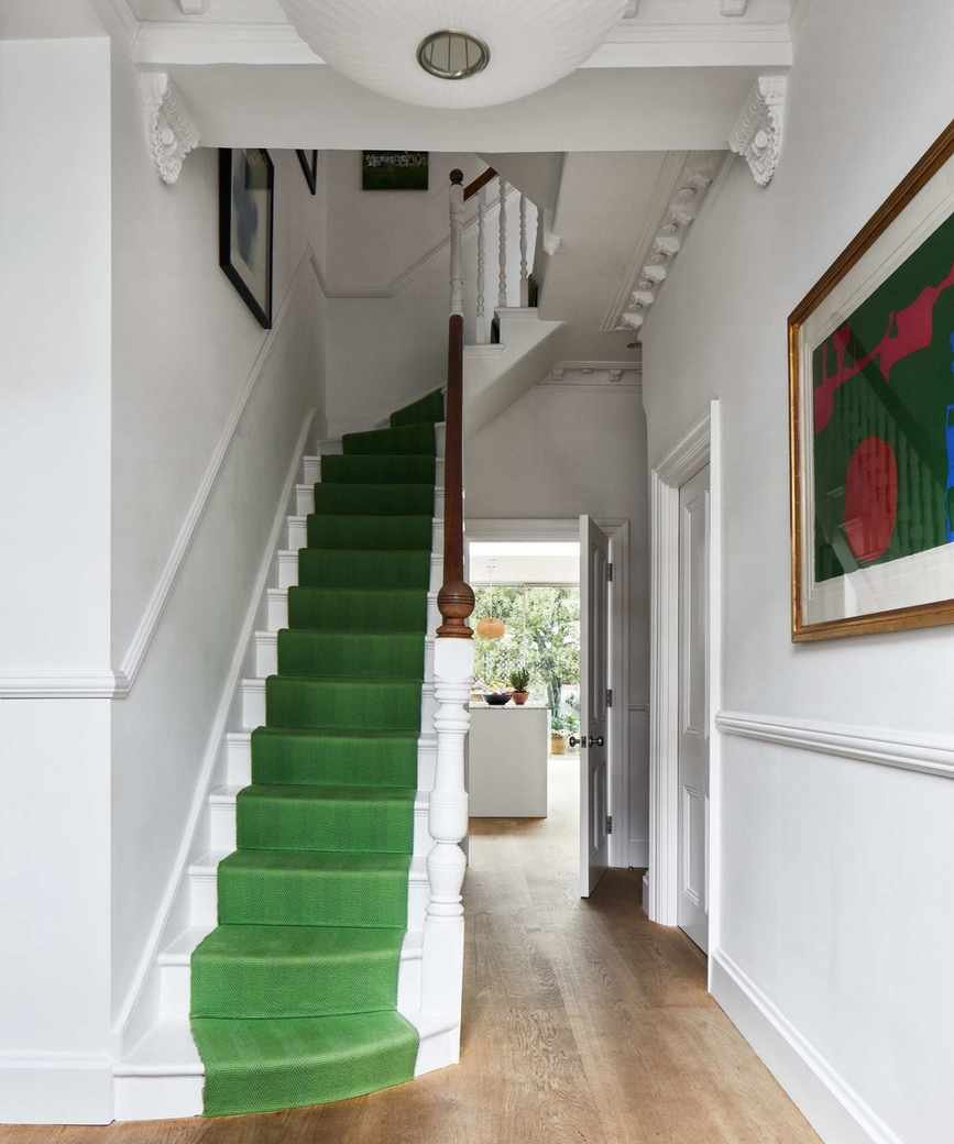 White hallway with bright green stair carpet