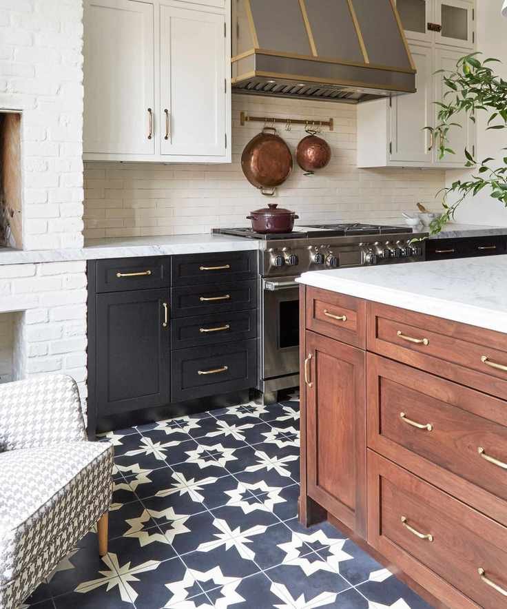 A wooden kitchen featuring vintage hardware and patterned floor tiles