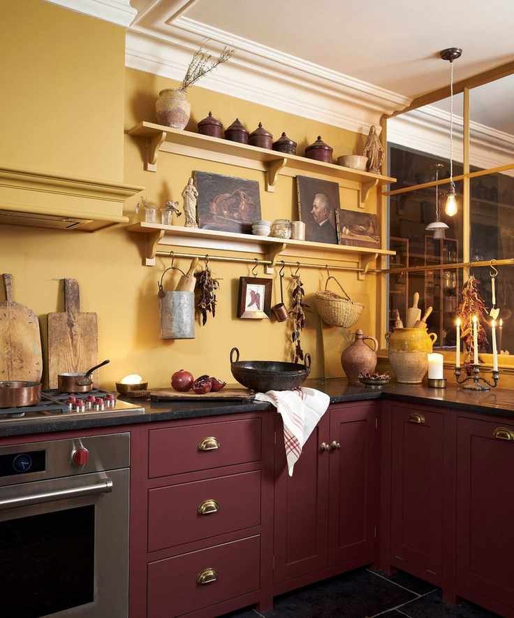 Red and yellow rustic kitchen by deVOL