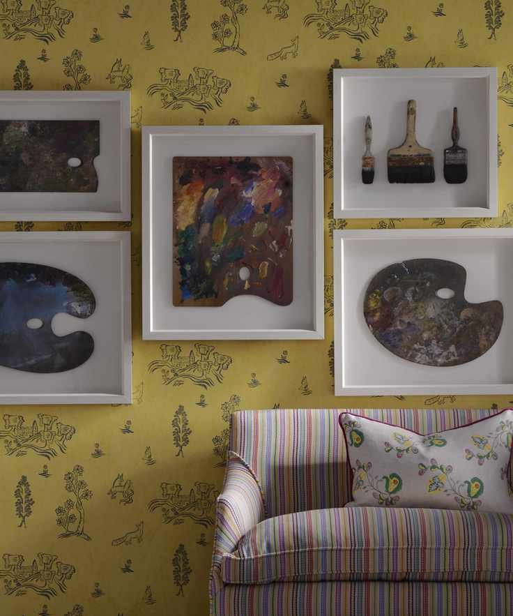 A yellow living room featuring yellow and gray patterned wallpaper behind a striped couch