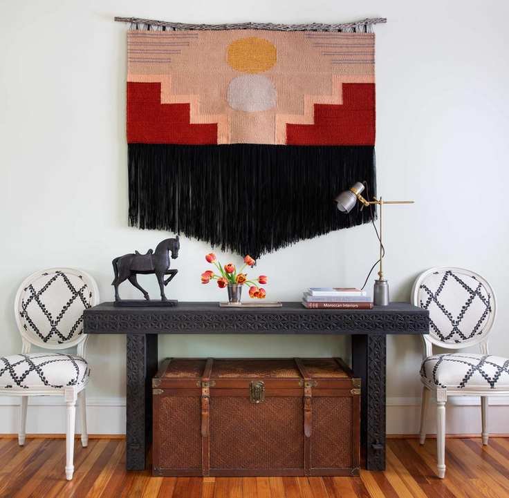 console table with side chairs and wall hanging