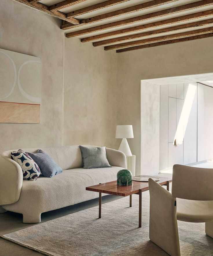 Living room featuring a sculptural beige sofa and artwork.