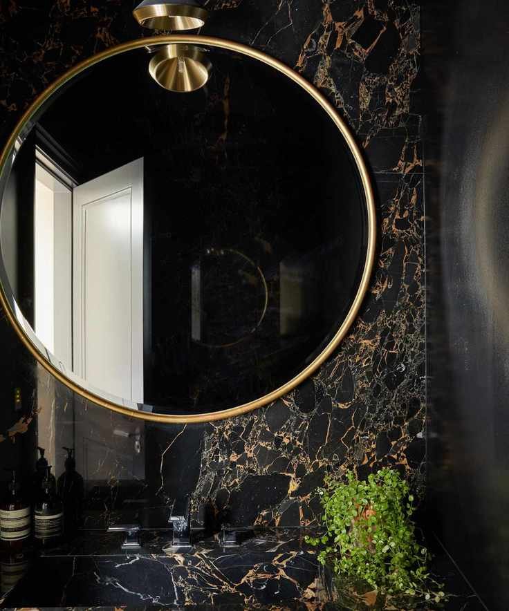 Dark powder room with large mirror