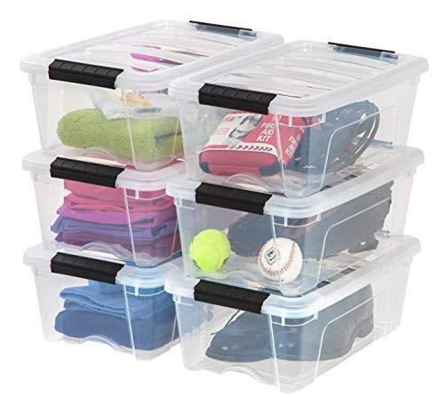 A set of six clear plastic storage bins stacked in two piles of three with sports gear inside, clip-on lids.