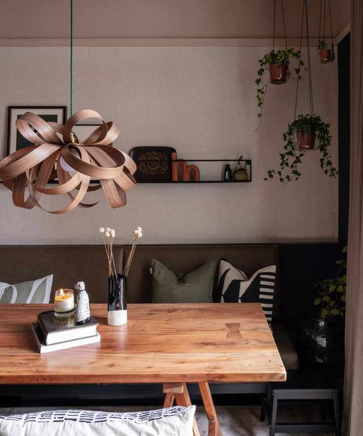 warm vs cool colors, neutral dining space with hanging plants, bent wood pendant light, bench seating, earthy colors, open shelf