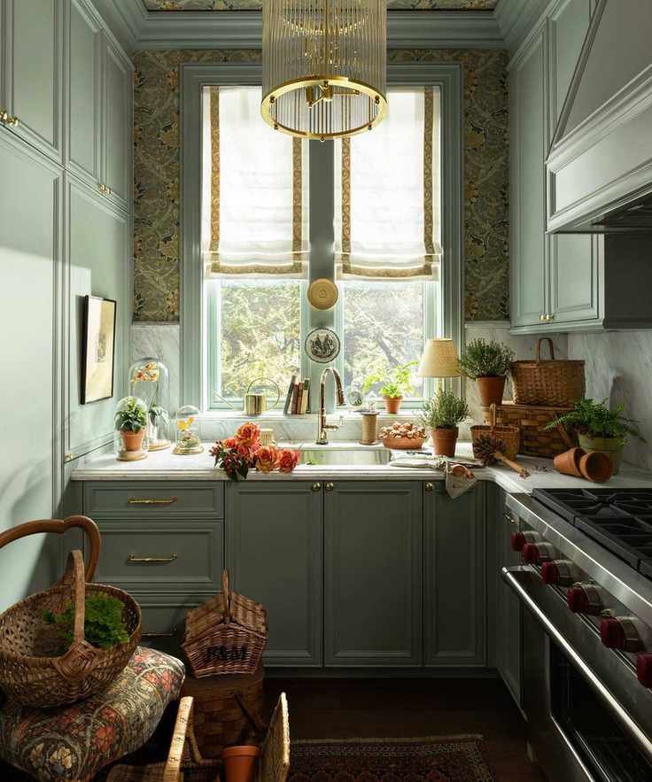 a soft green pantry with floral wallpaper on the ceiling, a window dressed with linen blinds and lots of potted plants and flowers decorating the countertop and window