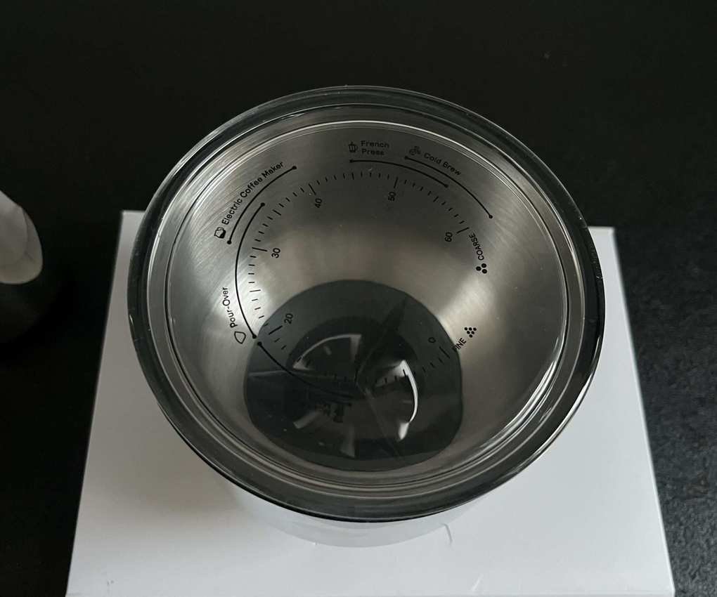 A close up of the glass lid of the Aarke coffee grinder, etched with the grind settings suitable for each type of coffee brewing method