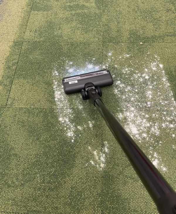 Tineco Pure One Station vacuuming flour and sugar on green carpet