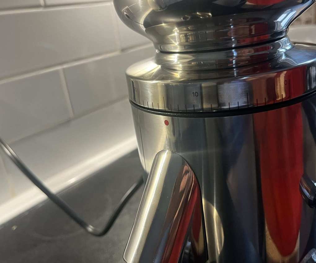 A close up image of the grind settings on a stainless steel coffee grinder