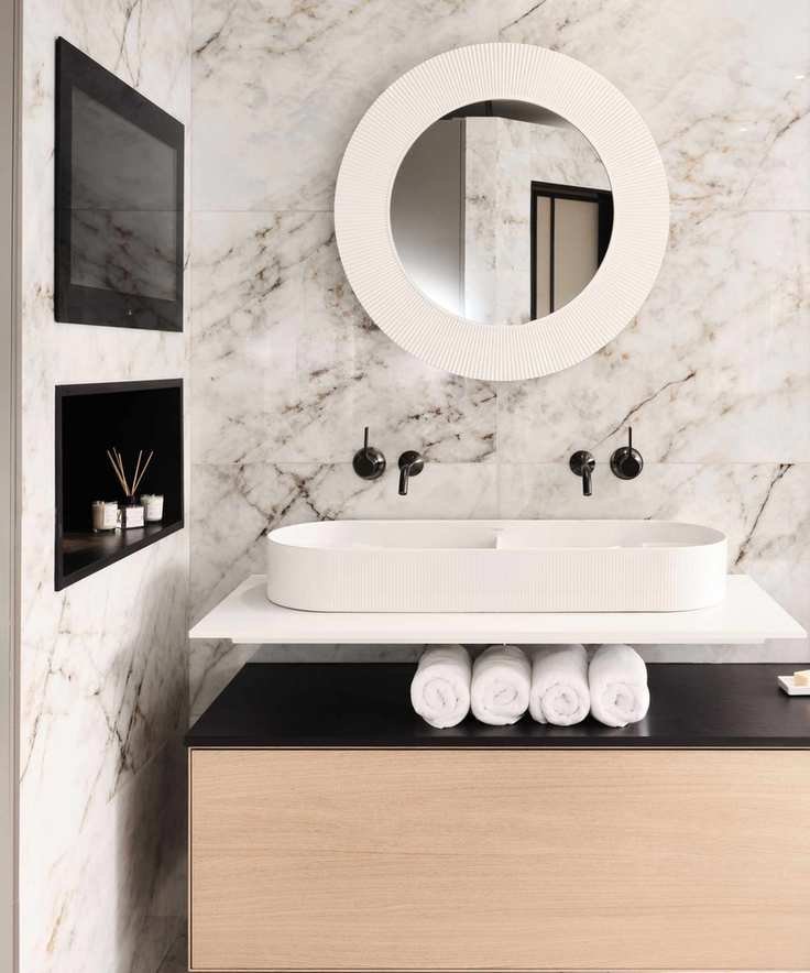 Bathroom with marble finishes and a niche for toiletries
