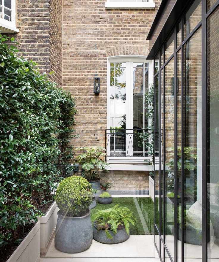 A patio area to the side of a house with plant pots