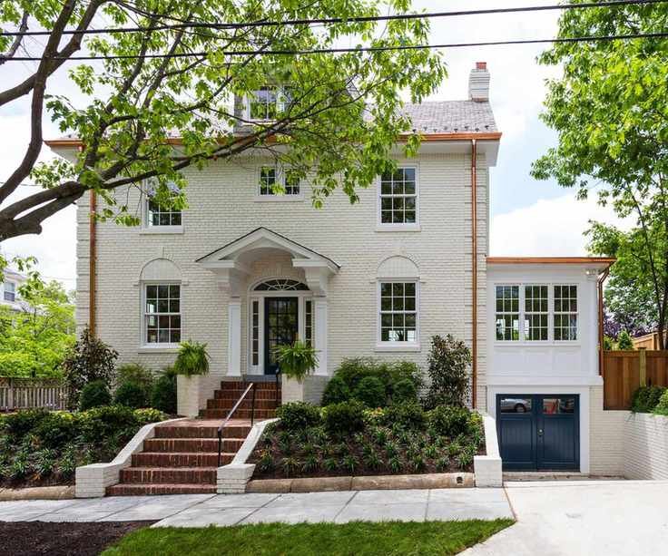 house exterior with cream painted brick with trees around