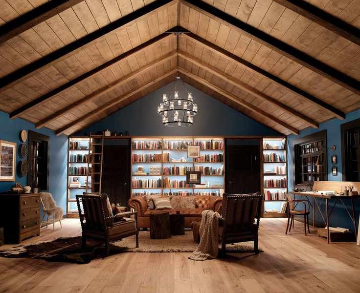 Kichler Lighting show how to plan living room lighting with ceiling and wall lighting in a large dark blue room with built in bookcases and leather chairs.