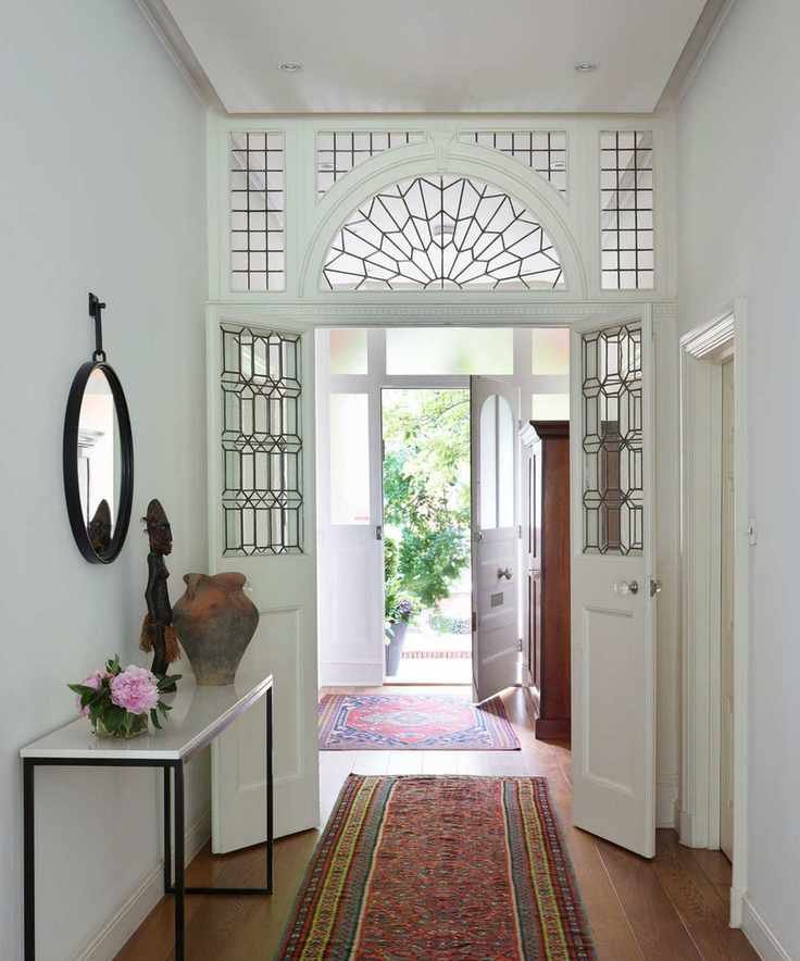 Hallway with glass paned door, wooden floor and vintage rugs
