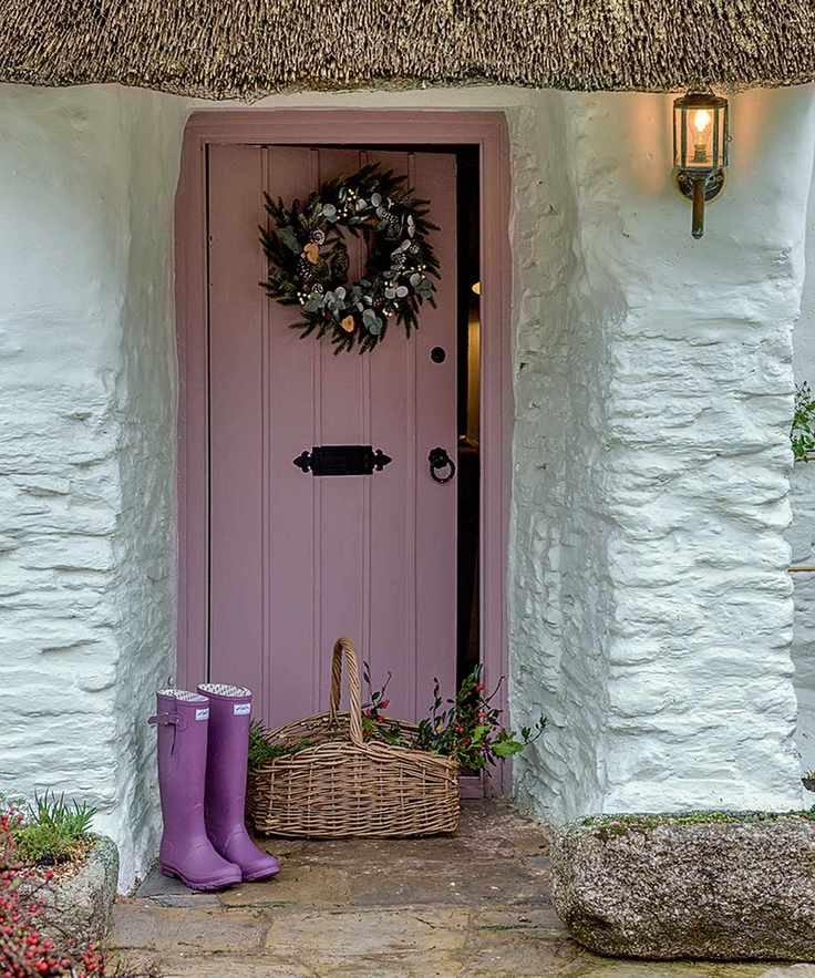 pink door with wreath and wellington boots
