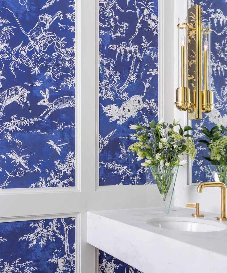 cloakroom with blue wallpaper and gold taps and wall light and white sink