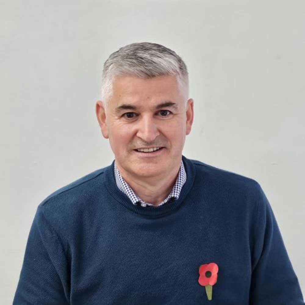headshot of Allan Reid, a window expert with grey hair and wearing a blue jumper