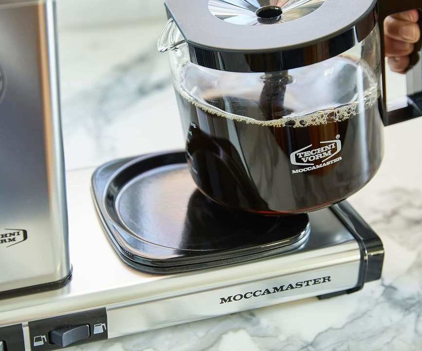 Moccamaster KGBV Select carafe full of coffee being lifted off the hot plate