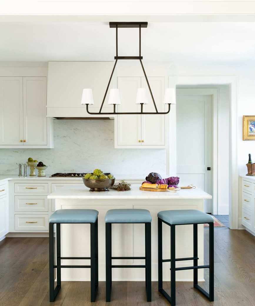 A white kitchen with blue bar stools