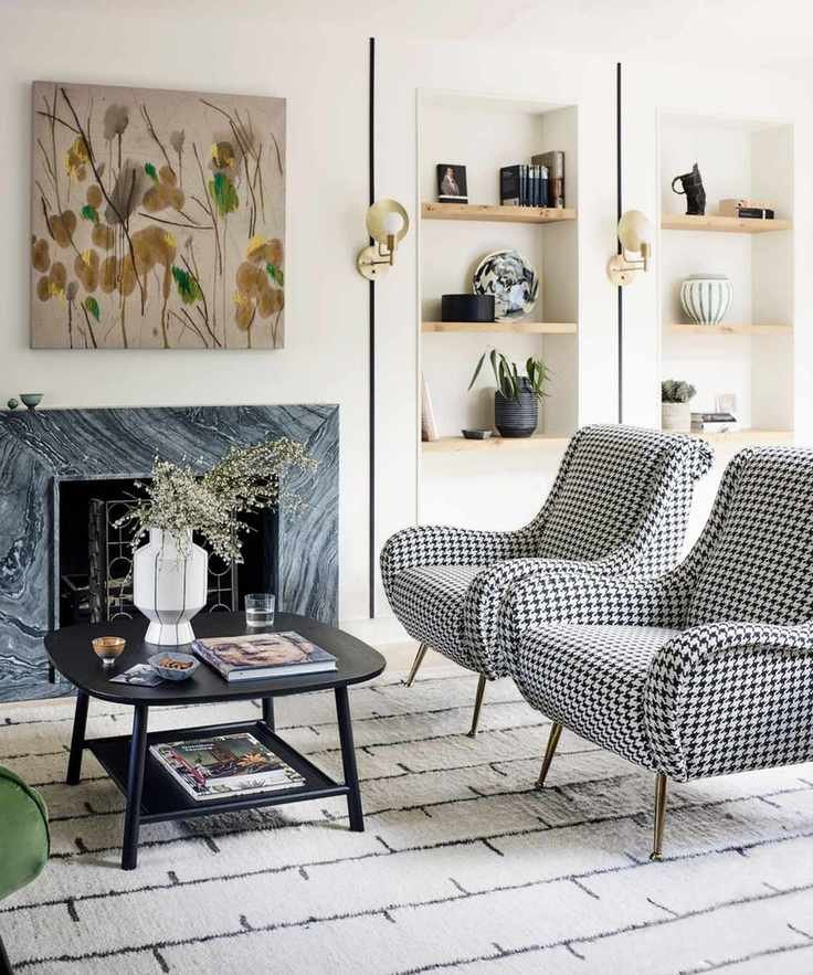 Living room with open layout with marble fireplace and black and white chairs