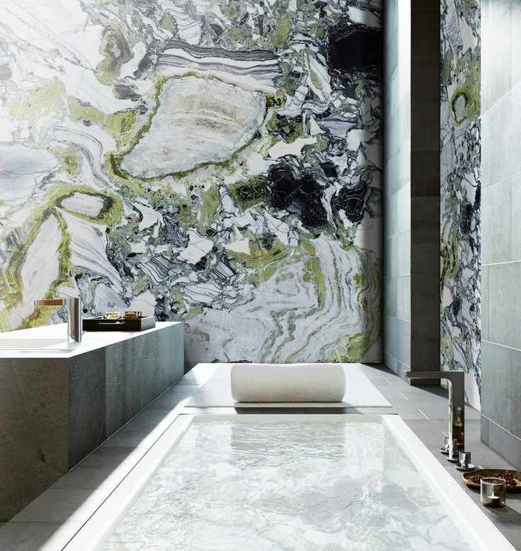 A stylish bathroom with an inset tub and stone walls
