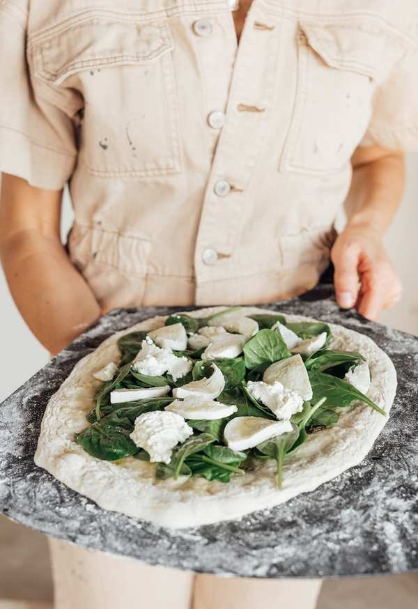 Spinach and ricotta pizza fresh from the oven on pizza stone