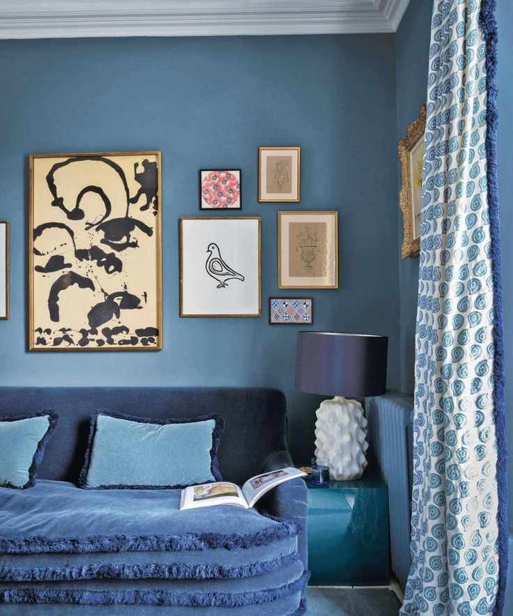 blue living room with blue sofa and gallery wall
