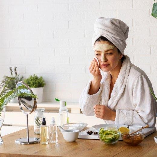 Woman in bathrobe with skincare and face mask
