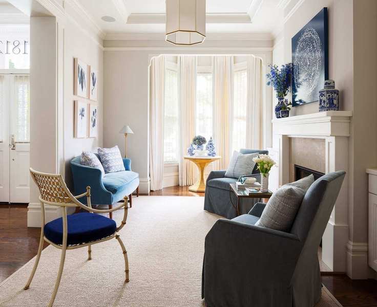 Beige living room with blue accents and a calming rug.