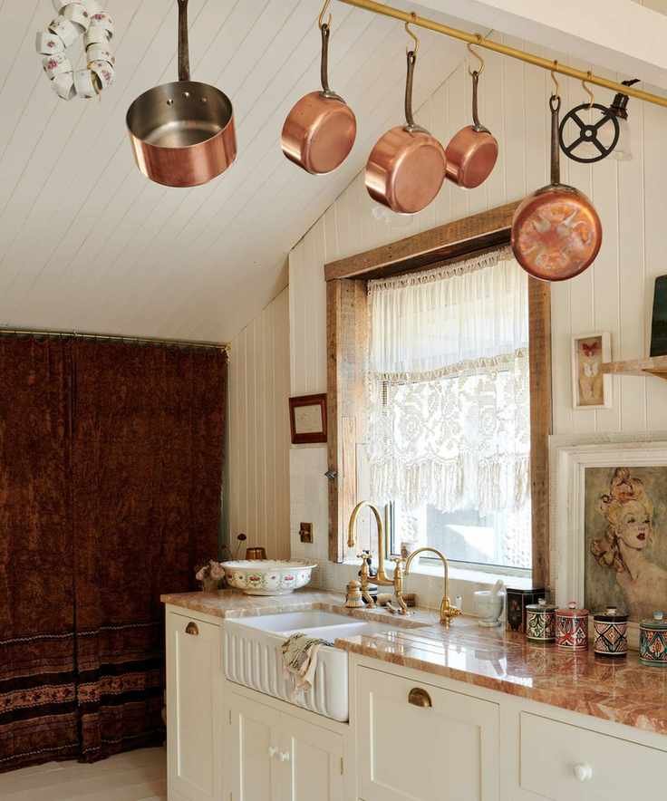 Angled shot of cream lower cabinets in a kitchen with orange stone counters